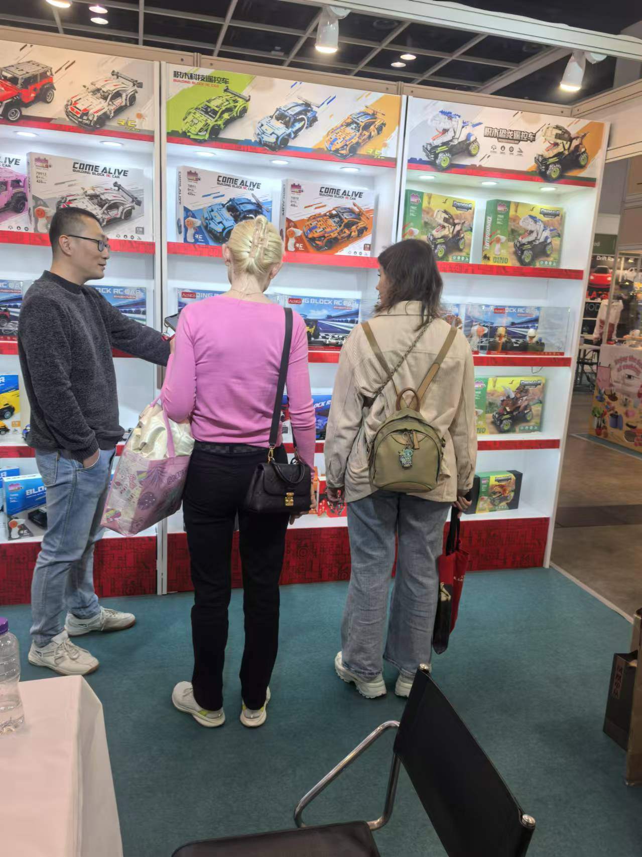 Buyers reviewing building-block toys at a Chenghai exhibition booth
